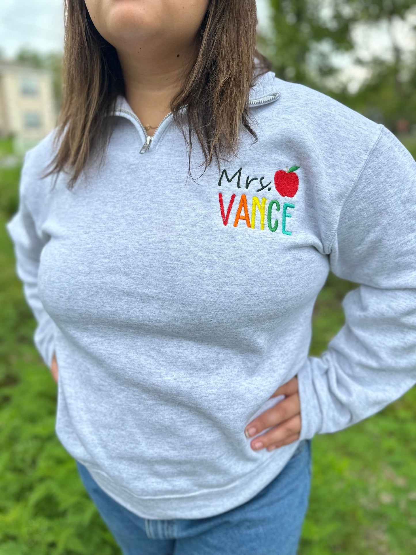 Personalized Teacher Name Quarter Zip Sweater Shown in Ash Color - Teachers name is Embroidered in Rainbow with an apple - On Model