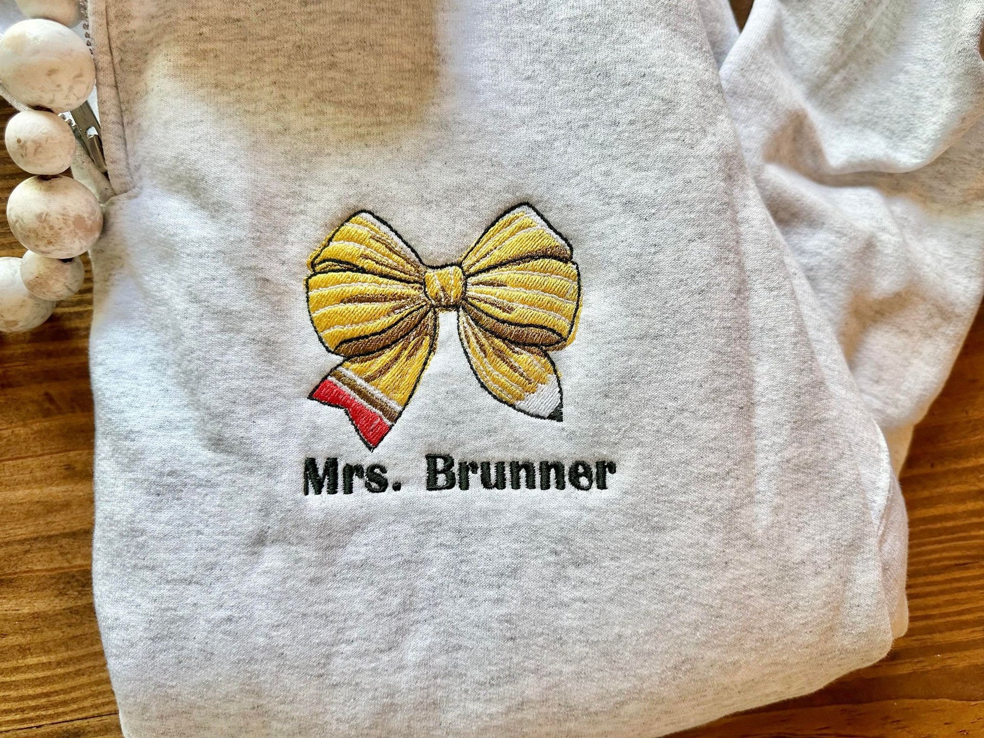 Pencil Bow with Personalized Teacher Name on Quarter Zip Sweater -Flat Lay