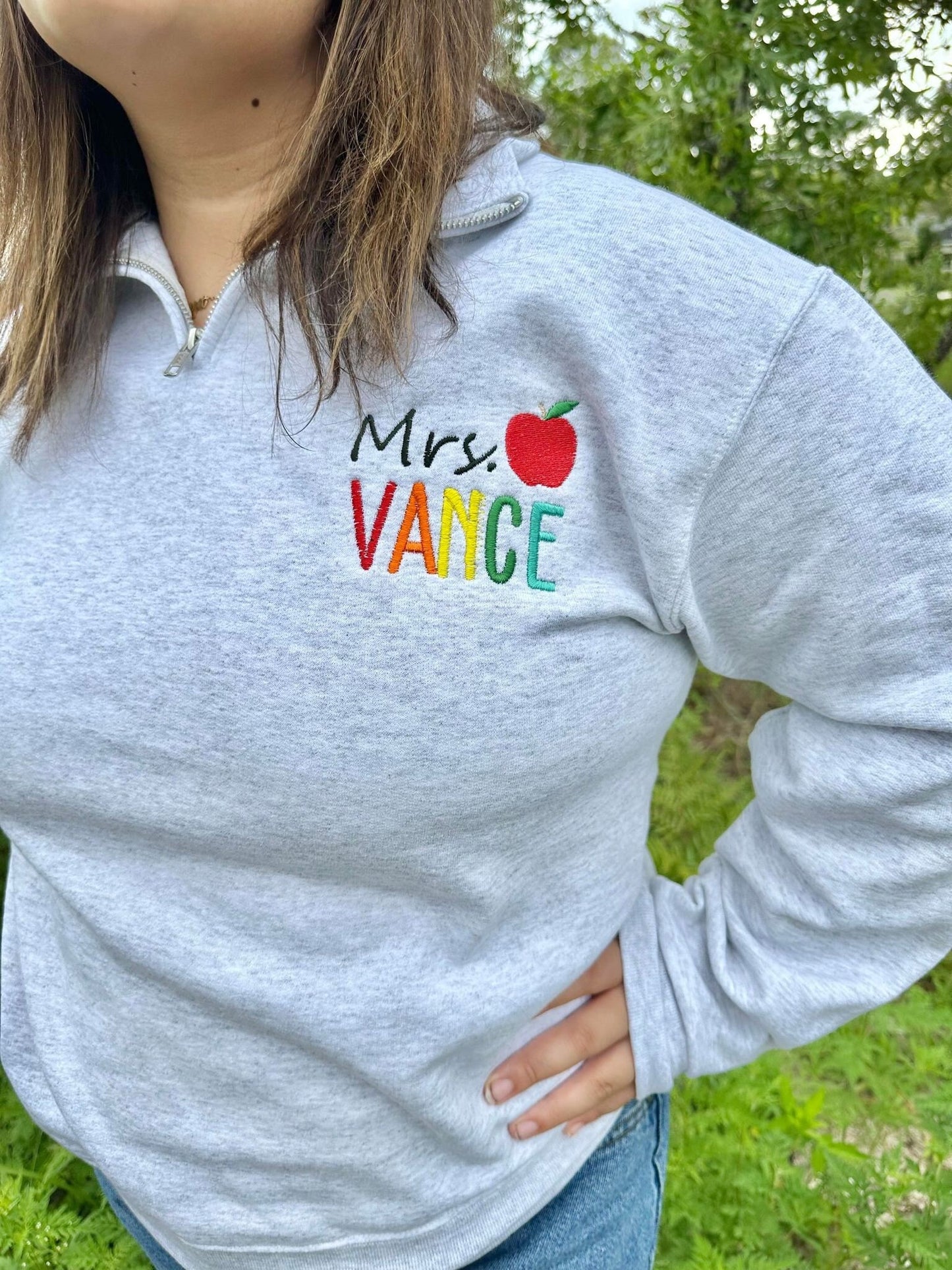 Personalized Teacher Name Quarter Zip Sweater Shown in Ash Color - Teachers name is Embroidered in Rainbow with an apple - On Model