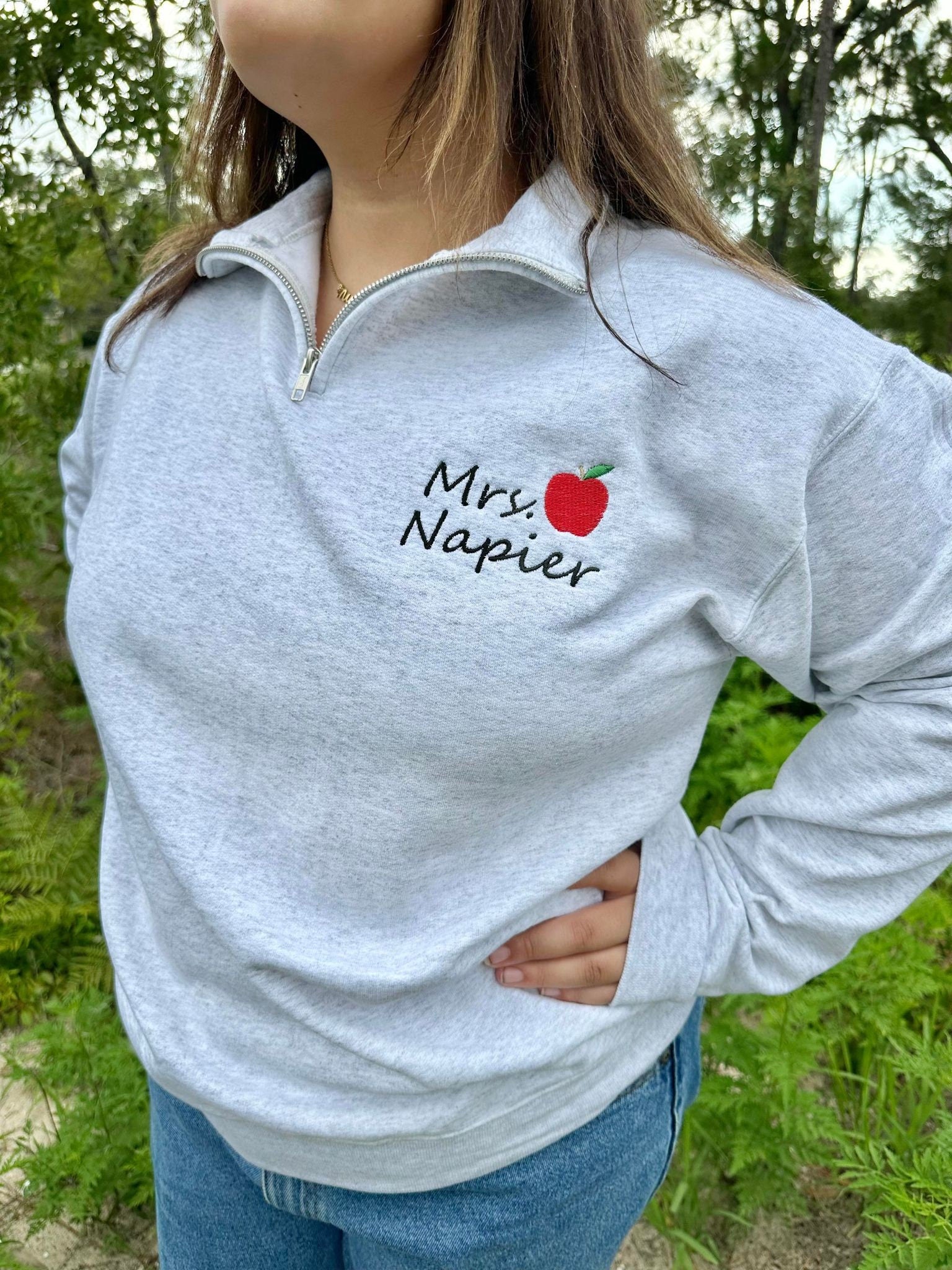 Embroidered Teacher name with Apple on Quarter Zip Sweater shown in the Color Ash - On Model