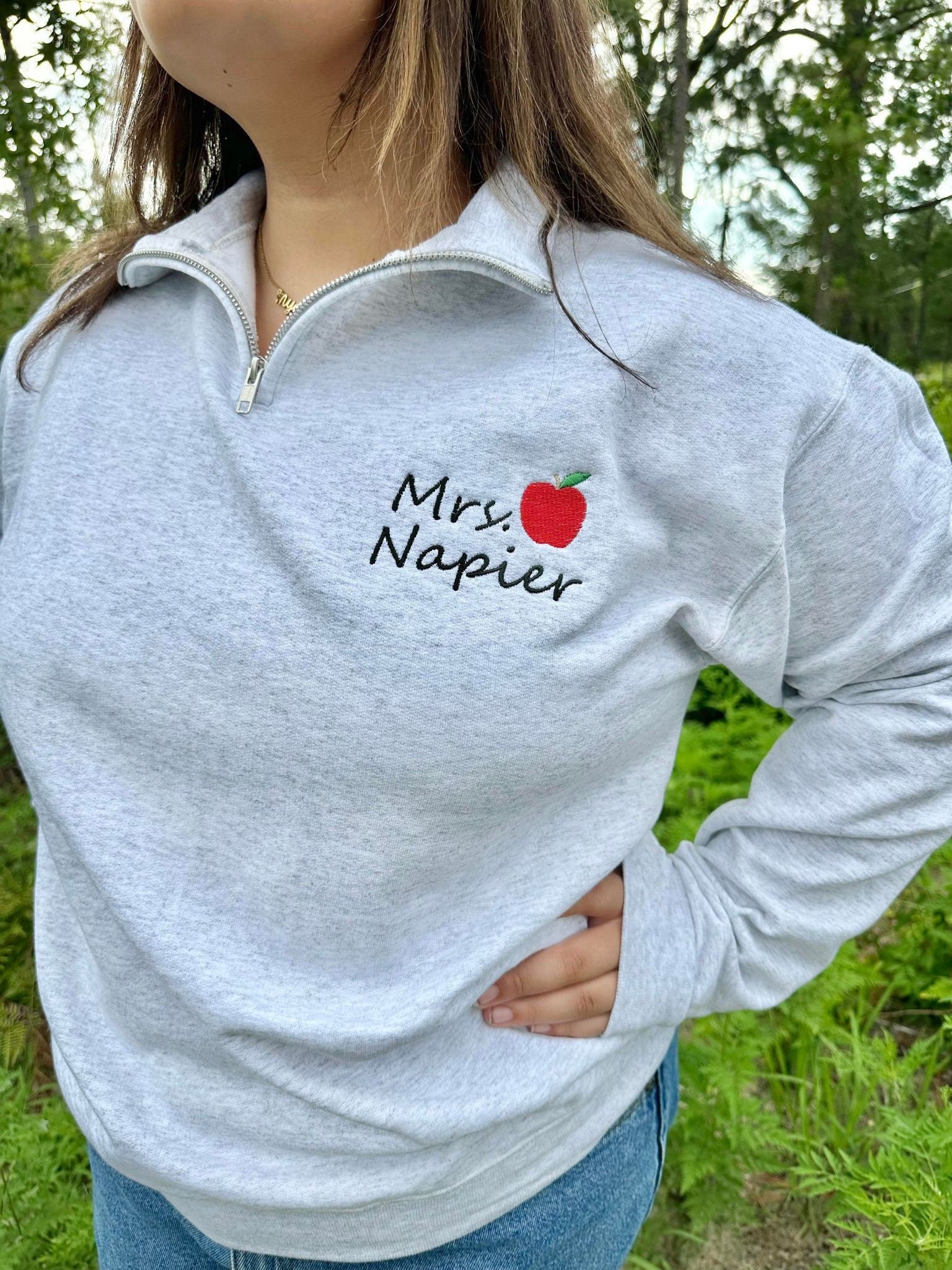 Embroidered Teacher name with Apple on Quarter Zip Sweater shown in the Color Ash - On Model