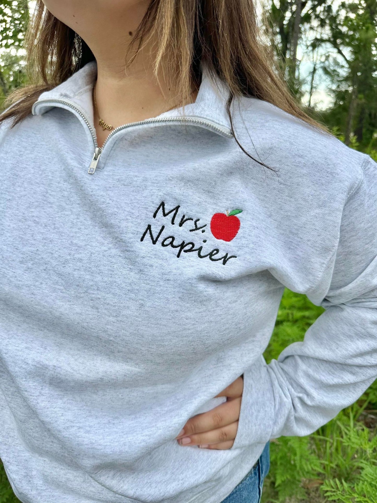 Embroidered Teacher name with Apple on Quarter Zip Sweater shown in the Color Ash - On Model