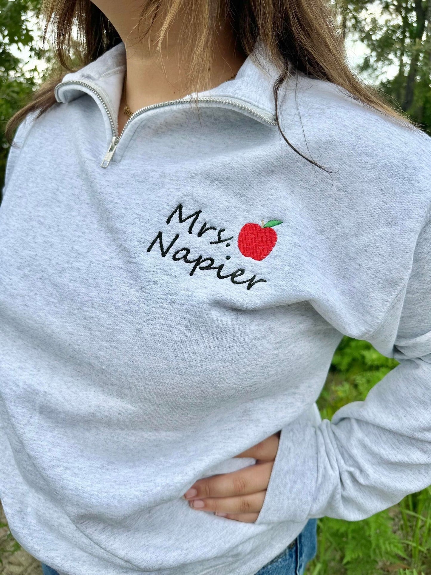 Embroidered Teacher name with Apple on Quarter Zip Sweater shown in the Color Ash - On Model